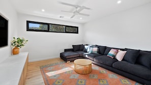 Relax in this stylish living room with a dark grey sofa, round coffee table, and colorful rug.