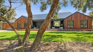 Set amidst a serene and lawn, this two-story building offers a tranquil retreat with large windows and a flat roof.