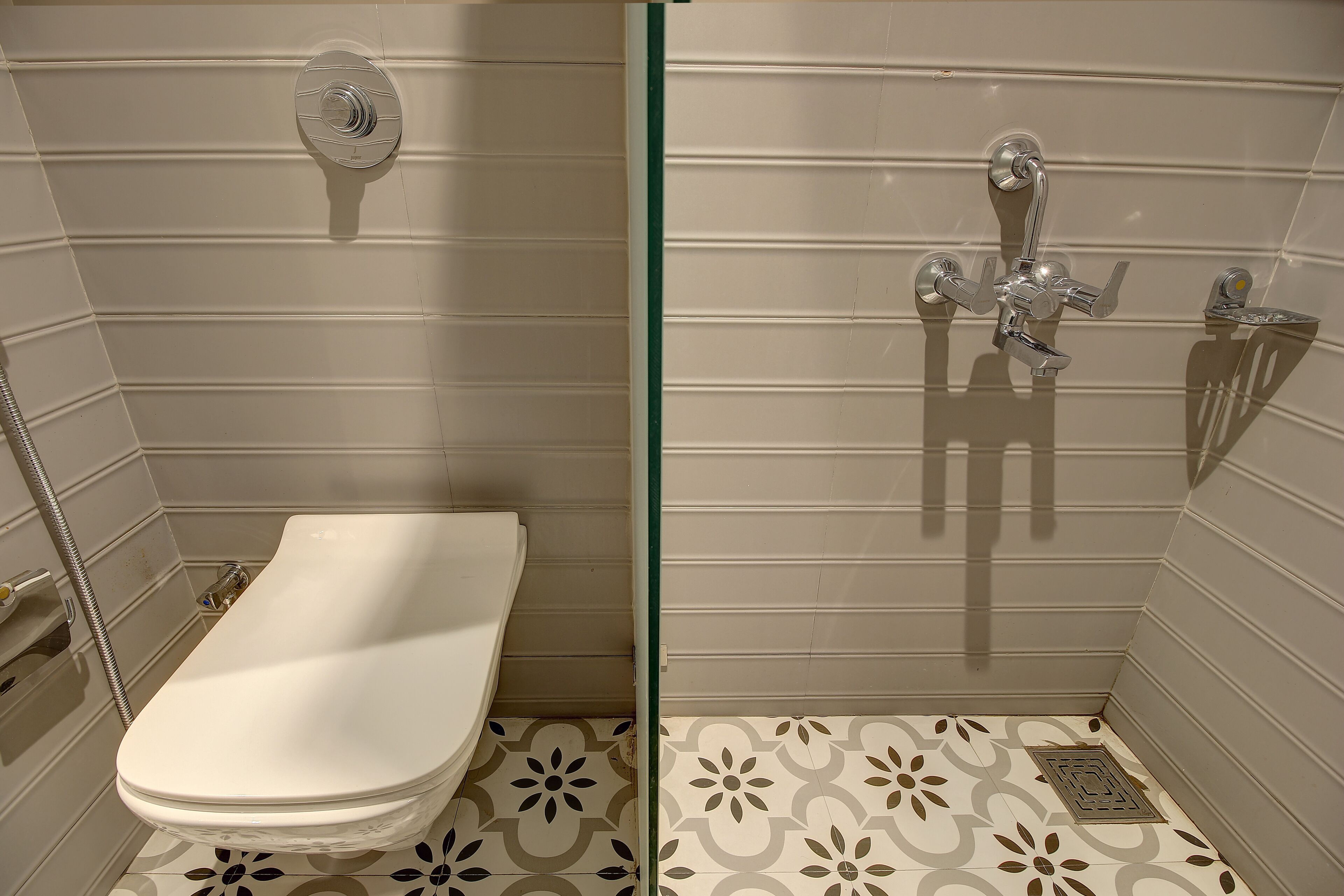 A bathroom with a toilet, a shower, and a glass partition.