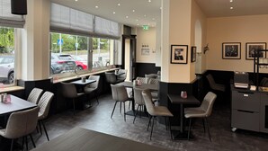 A modern restaurant interior with a seating area, tables, chairs, and a counter. - Panorama Hotel Rheinkrone (Andernach)
