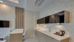 A modern kitchen with a built-in island, a flat-screen TV, and a large mirror above the counter.