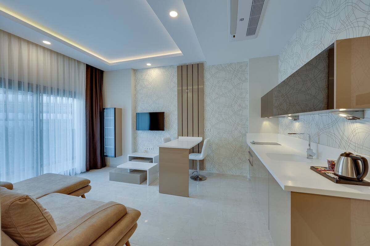 Une chambre d’hôtel moderne comprenant un coin salon, un coin repas et une kitchenette.