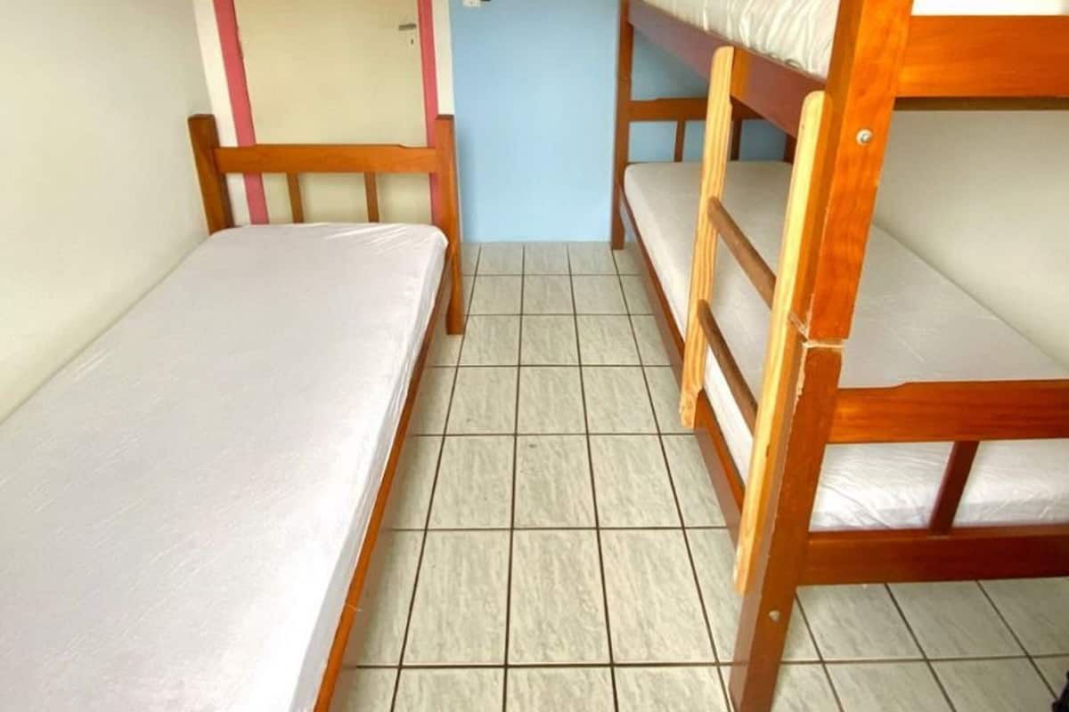 Una habitación pequeña y estrecha con una puerta y dos literas.