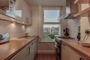 Departamento, 1 cama Queen size y sofá cama | Cocina privada | Refrigerador, microondas, horno y parrilla de estufa