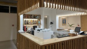 Un área de bar con paneles de madera, un mostrador de licores y una máquina de café FUTURMAT.