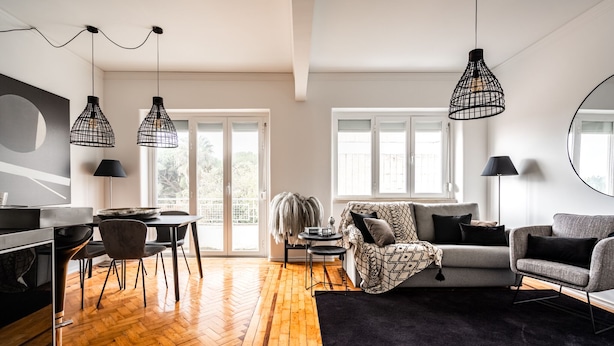 Un salon moderne comprenant un canapé, un coin repas avec une table et des chaises, et un espace cuisine avec une cuisinière.