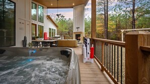 A hot tub on a wooden deck with a view of a house and trees. - NEW Spectacular Modern Retreat -The Fika House-Lux (Broken Bow)