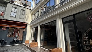 Un immeuble à deux étages, avec un commerce au rez-de-chaussée et des logements aux étages supérieurs.