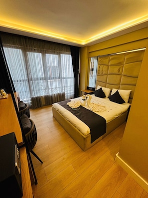 Ein Hotelzimmer mit einem großen Bett, einem Schreibtisch und einem Stuhl.