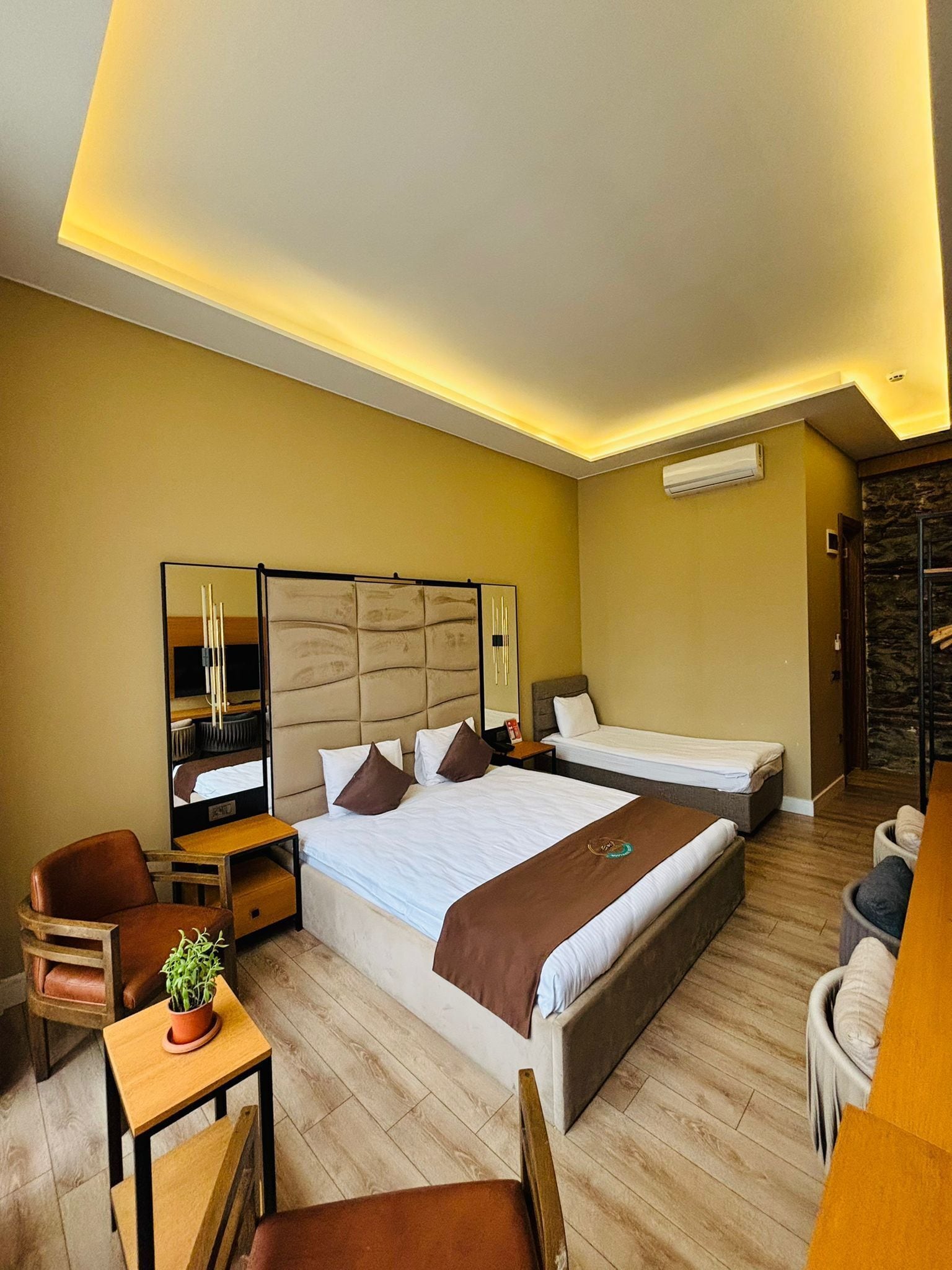 A modern hotel room with a large bed, a desk, and a chair.