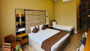 A modern hotel room with a large bed, a desk, and a chair.