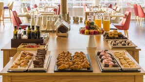 Un bufé de desayuno con pasteles, pan y bebidas.