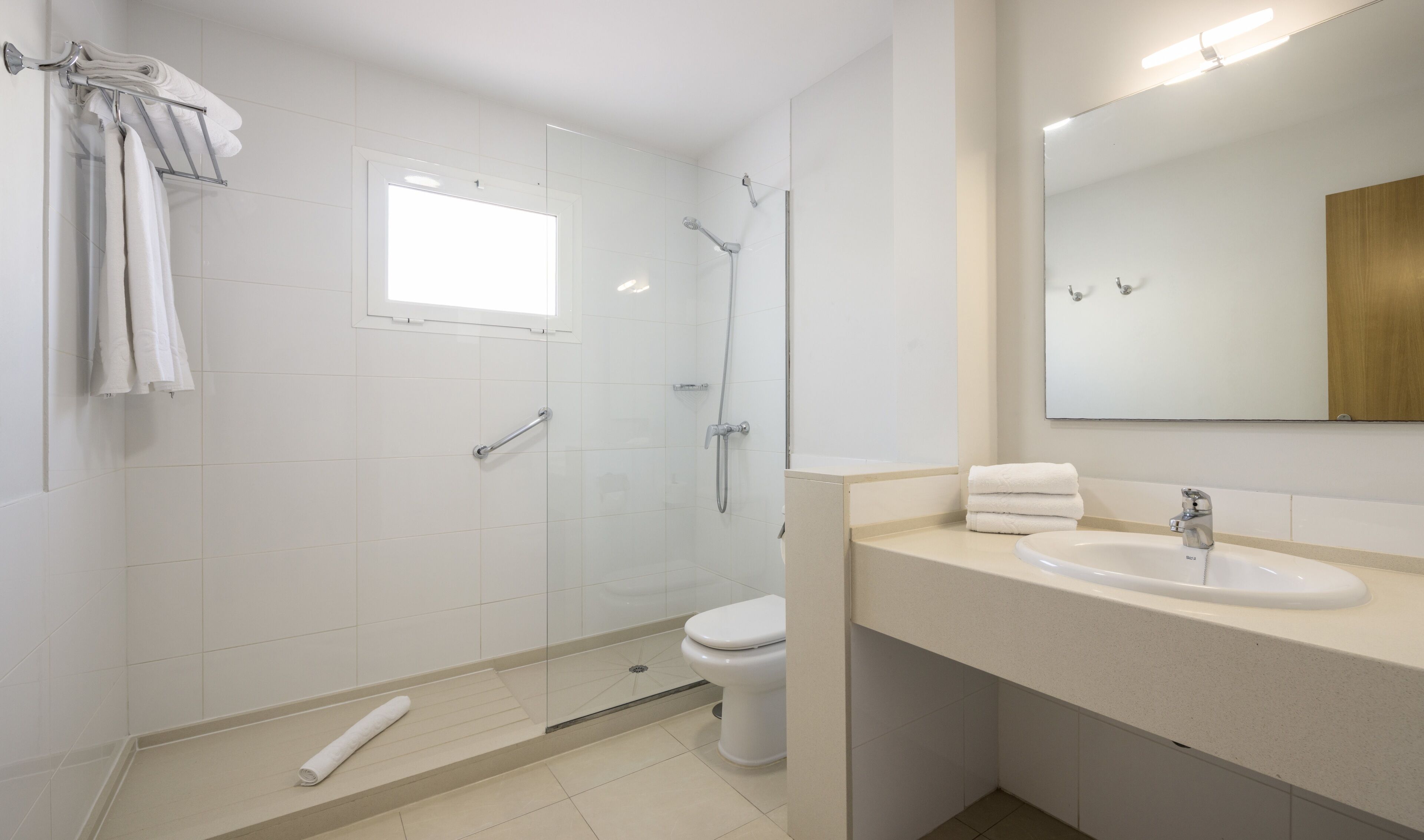 Een moderne badkamer met een douche, toilet en wastafel.