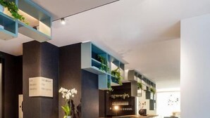 Un área de recepción moderna con mostrador, asientos y una zona de bar.
