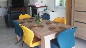 Ein Essbereich mit Holztisch, blau-gelben Stühlen und gewebten Platzsets.