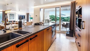 Una cucina moderna con una grande isola, forno integrato e zona pranzo con vista.