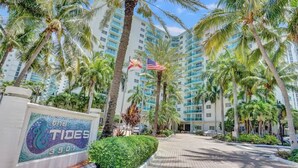 A hotel entrance with palm trees, a sign reading "The Tides 3901", and a clear sky. - The Tides on the Beach by Aurich Designs (Hollywood)