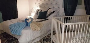 Quarto com cama, berço e piso estampado.