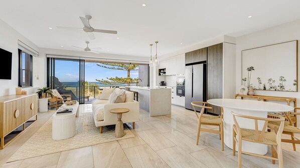Un espacio de estar moderno con cocina, comedor y un balcón con vistas.