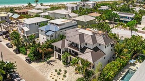 Zona residencial a la costa, amb cases, una piscina i una platja al fons.