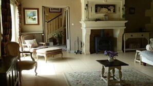 Un salon traditionnel avec une cheminée, un escalier et un coin repas.