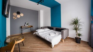 A modern bedroom with a bed, a desk, a chair, and a potted plant. - Azur Paradise near City Center (Oradea)