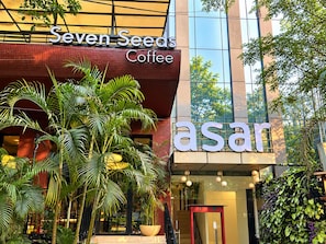 A building with a sign for 'Seven Seeds Coffee' and another sign for 'asar' with a staircase leading to the entrance. - asar Elite Green Park by Orion Hotels (New Delhi)
