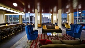 A spacious lobby with a bar area, seating arrangements, and large windows offering city views. - 1B1B  DTLA (Los Angeles)