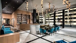 A modern hotel lobby with a seating area, a bar, and a library. - 1B1B  DTLA (Los Angeles)