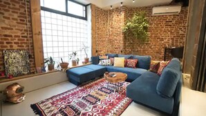Una sala de estar moderna con un sofá seccional azul, un tapete estampado y una mesa de centro.