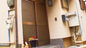 A residential building with a large wooden door, a small balcony, and a tiled entrance area. - 10mins train to Namba, 4mins walk to stn, 2floor Japanese style whole house (大阪市)