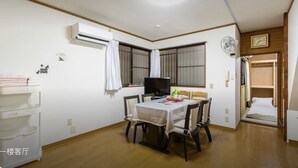 A room with a dining table, chairs, a TV, an air conditioner, and a bed. - 10mins train to Namba, 4mins walk to stn, 2floor Japanese style whole house (大阪市)