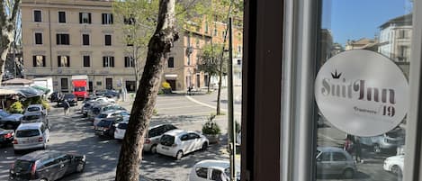 A view of a parking lot with cars and a tree in the foreground.