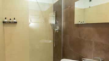 A modern bathroom with a glass-enclosed shower, a white sink, and a dark countertop.