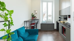 Eine moderne Küche mit grauer Arbeitsplatte, einem roten Backofen und einem Fenster über der Spüle.
