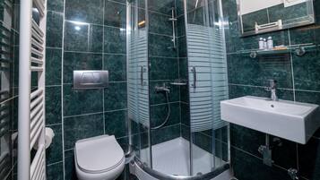 Ein modernes Badezimmer mit einer Glasdusche, einem weißen Waschbecken und einer Toilette.