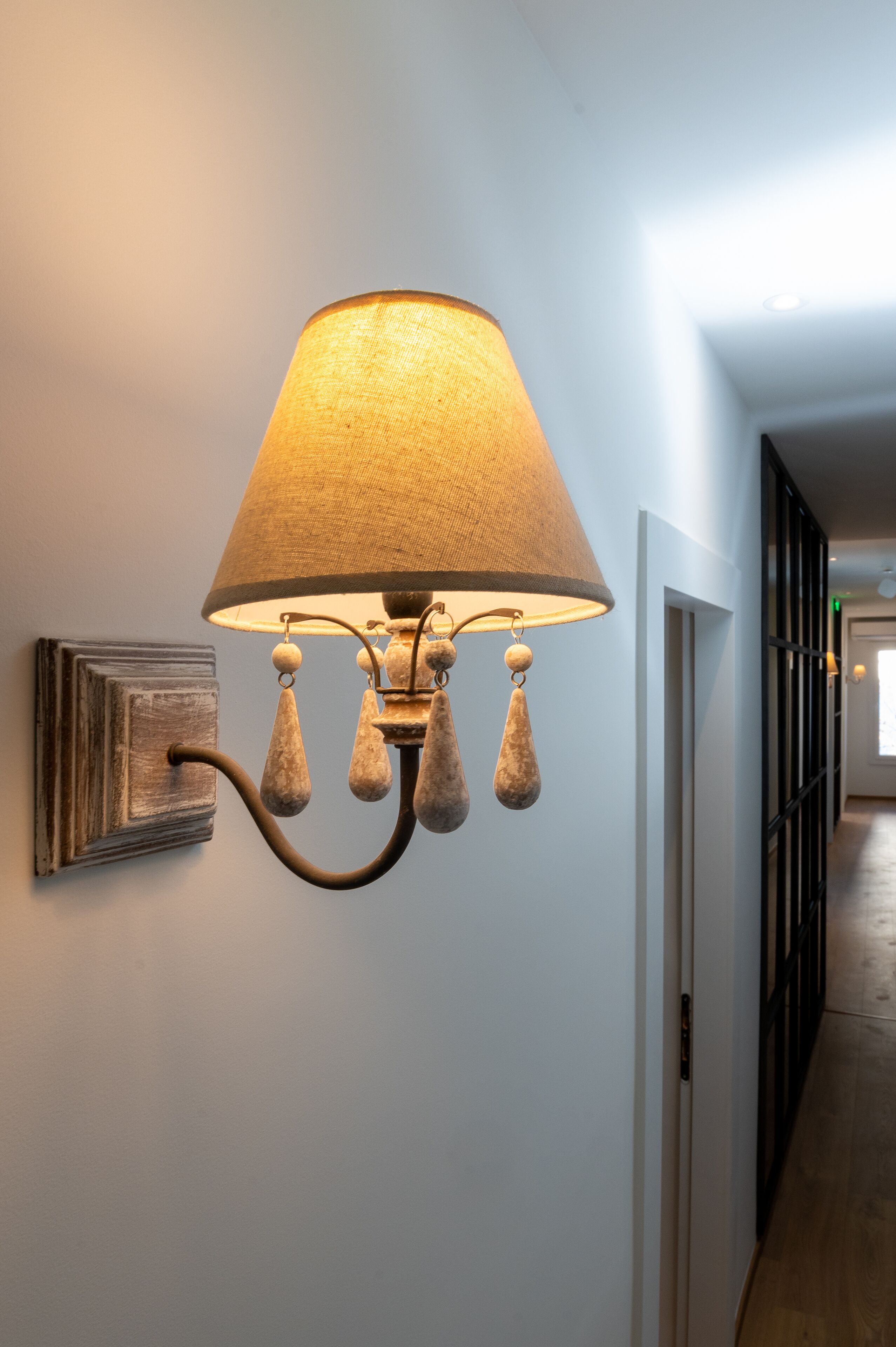A wall-mounted lamp with a fabric shade and decorative elements.