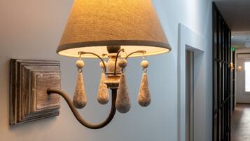 A wall-mounted lamp with a fabric shade and decorative elements.