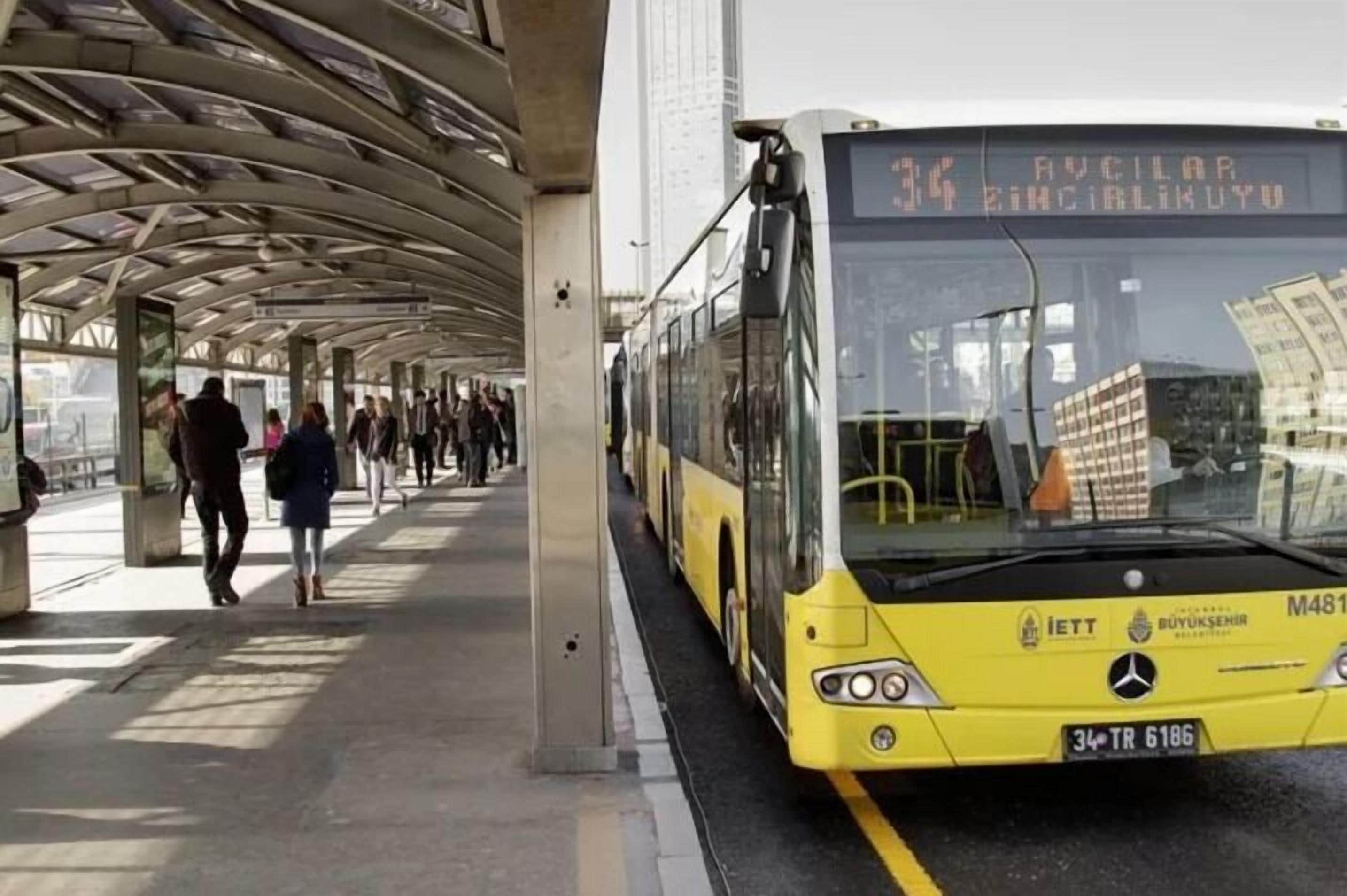 A yellow bus with the number 34 and destination "AUCILAR" at a bus station.