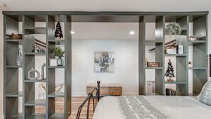 Un dormitorio moderno con una cama grande, estanterías empotradas y una decoración minimalista.