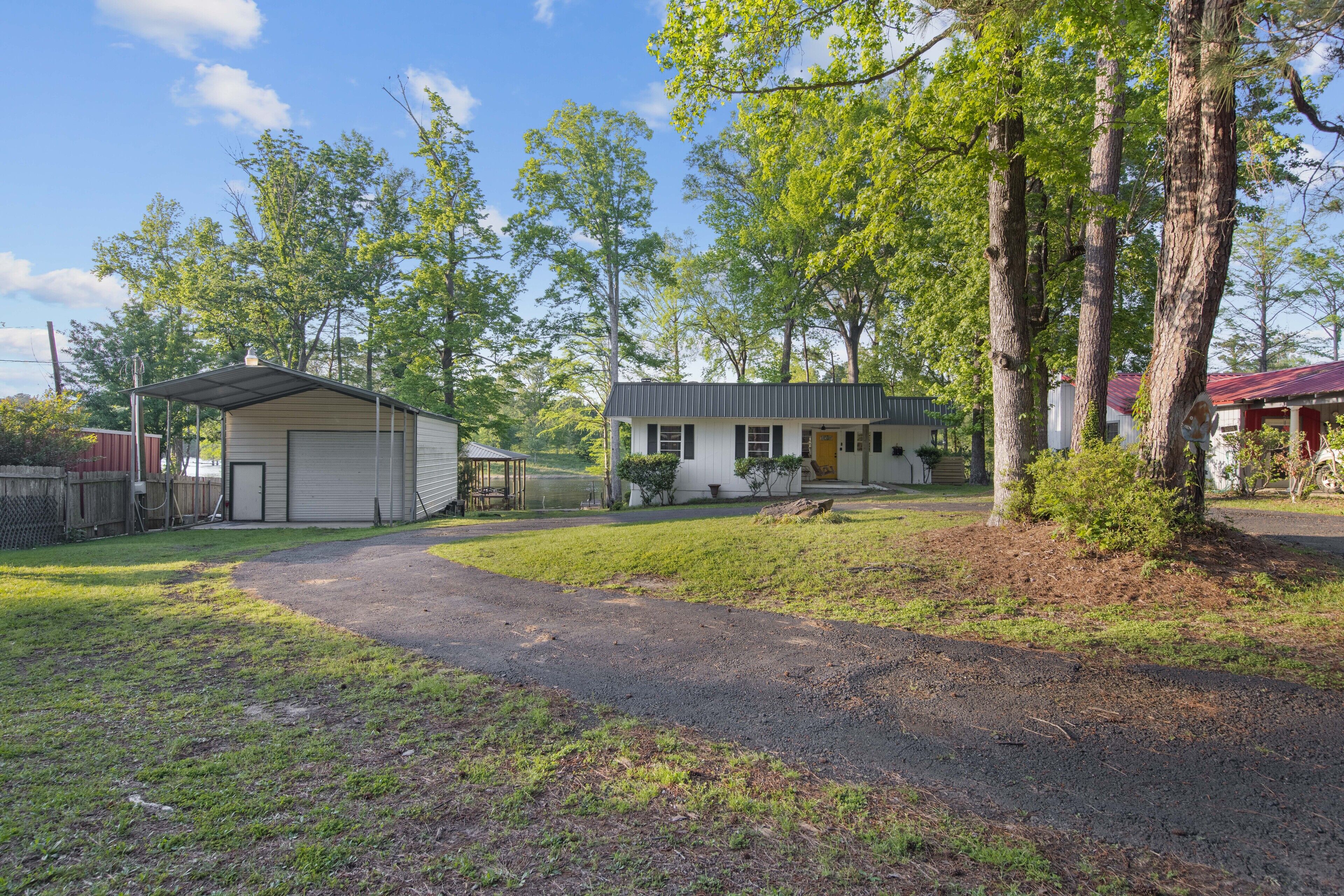 A single-story house with a garage, a covered porch, and a small shed.