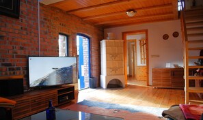 Relax in this inviting living room with a large flat-screen TV, comfortable seating area, and a glass coffee table.