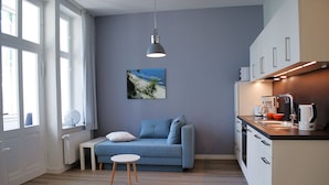 Una cucina moderna con un divano blu, un tavolino e una lampada a sospensione.