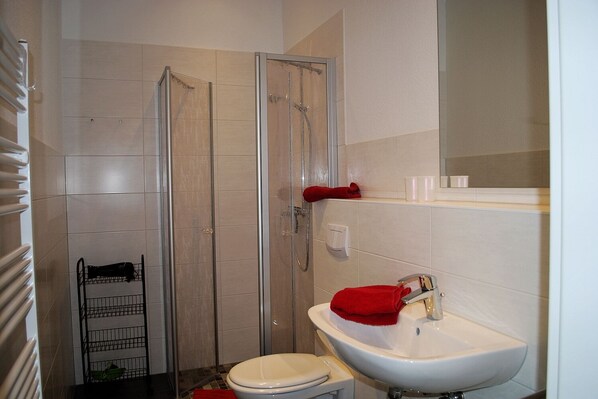 A bathroom with a shower, toilet, and sink.