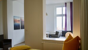 Et hotelværelse med en seng, et vindue med udsigt, en stol og et bord.