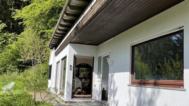 A house with a covered porch, large windows, and a view of the surrounding greenery. - Beautiful 8 Bed Apartment in Hallenberg (Hallenberg)