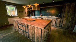 Una cocina con isla central, armarios de madera e iluminación colgante.