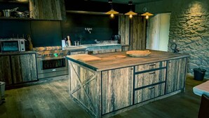 Una cocina moderna con una isla grande, armarios de madera y electrodomésticos de acero inoxidable.