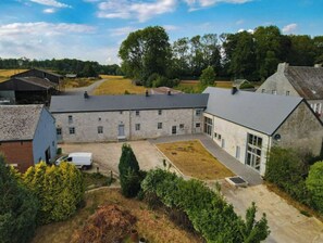 Een groot stenen gebouw met meerdere kamers, een binnenplaats en omliggend groen.