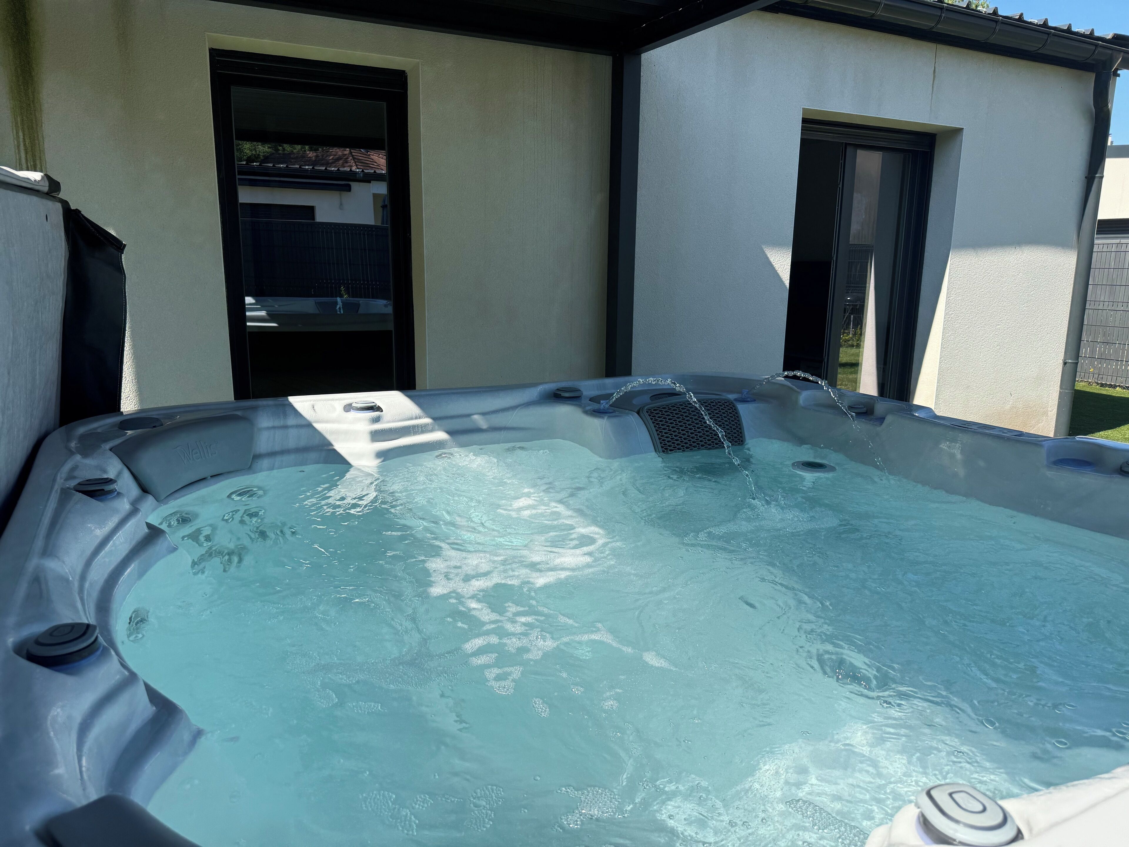Een kuip met warm water, bedieningspaneel, deur en raam.